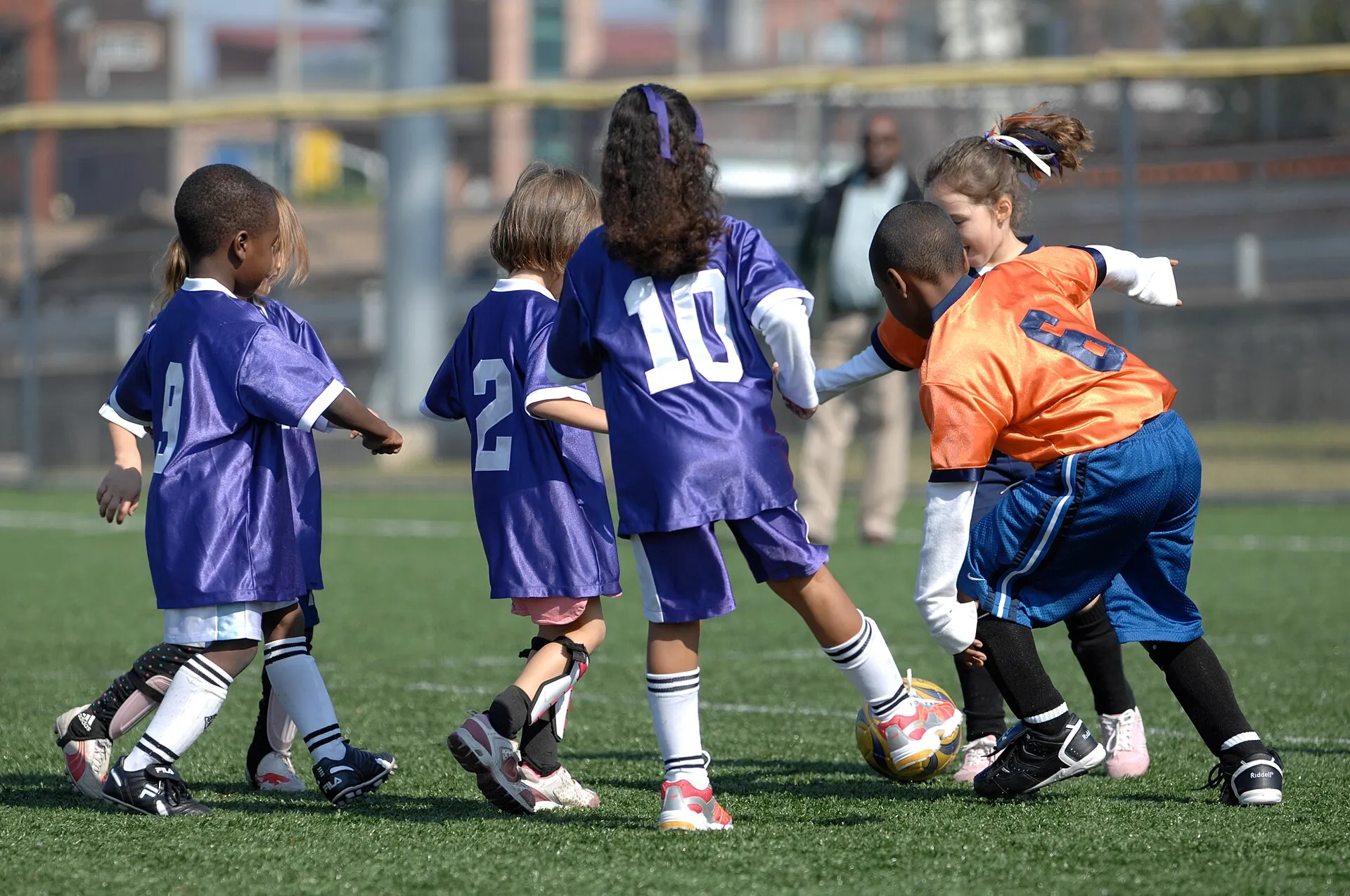 Niñas y niños jugando futbol en una cancha