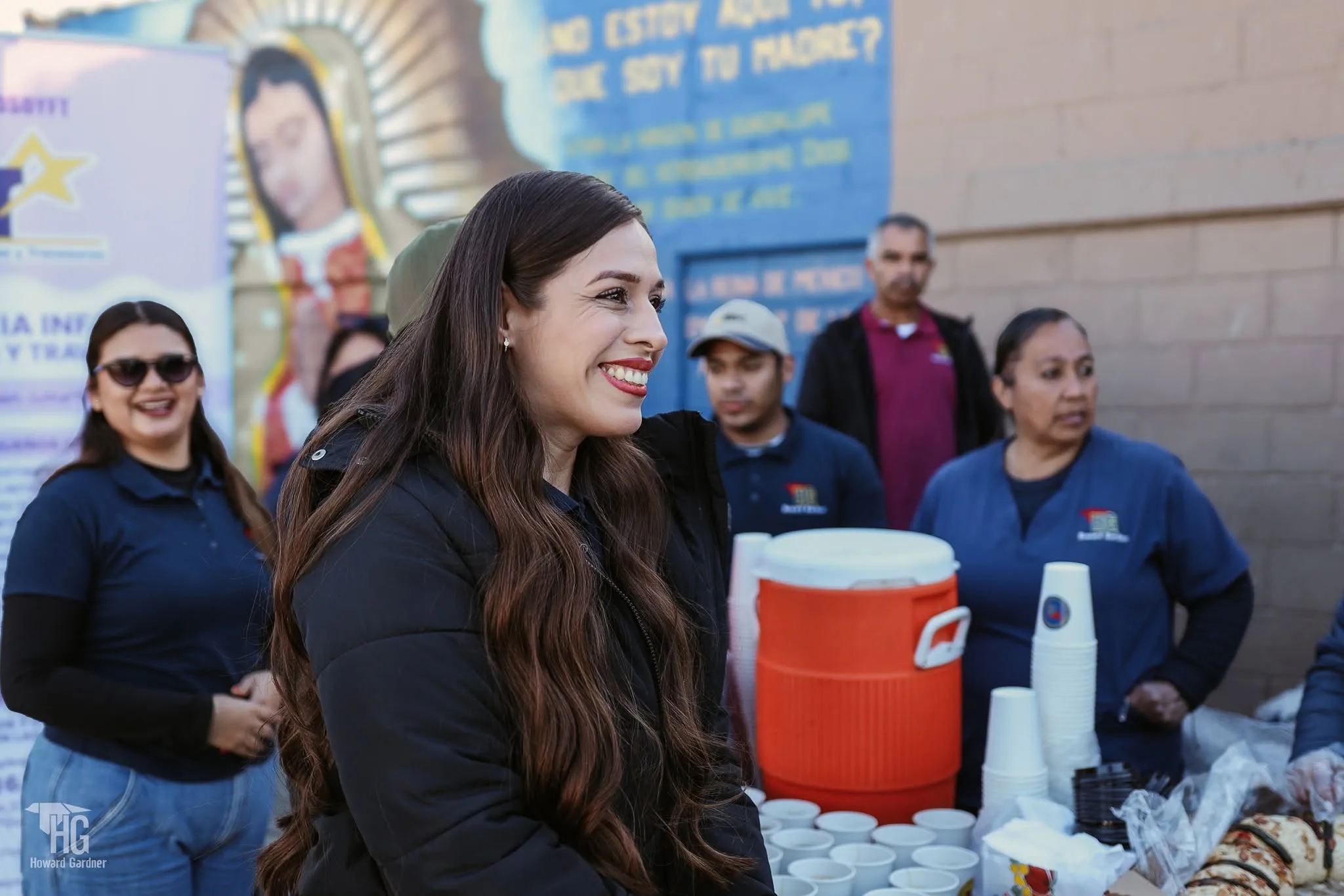 Voluntarias sonrientes junto a la mesa de bebidas calientes
