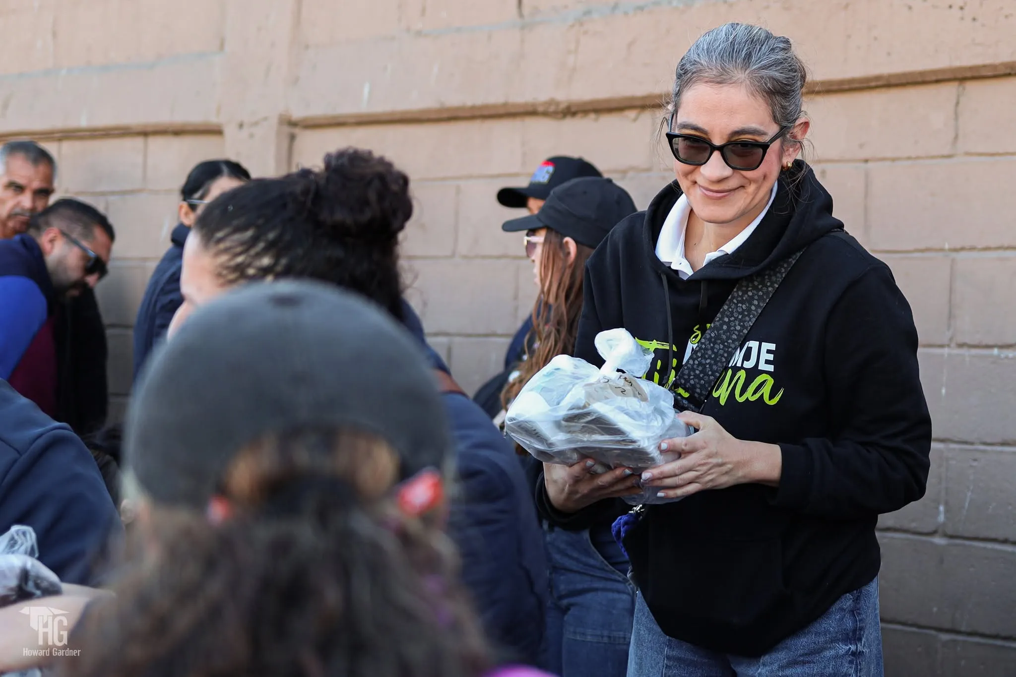 Una voluntaria sonríe con un par de zapatos listo para entregar