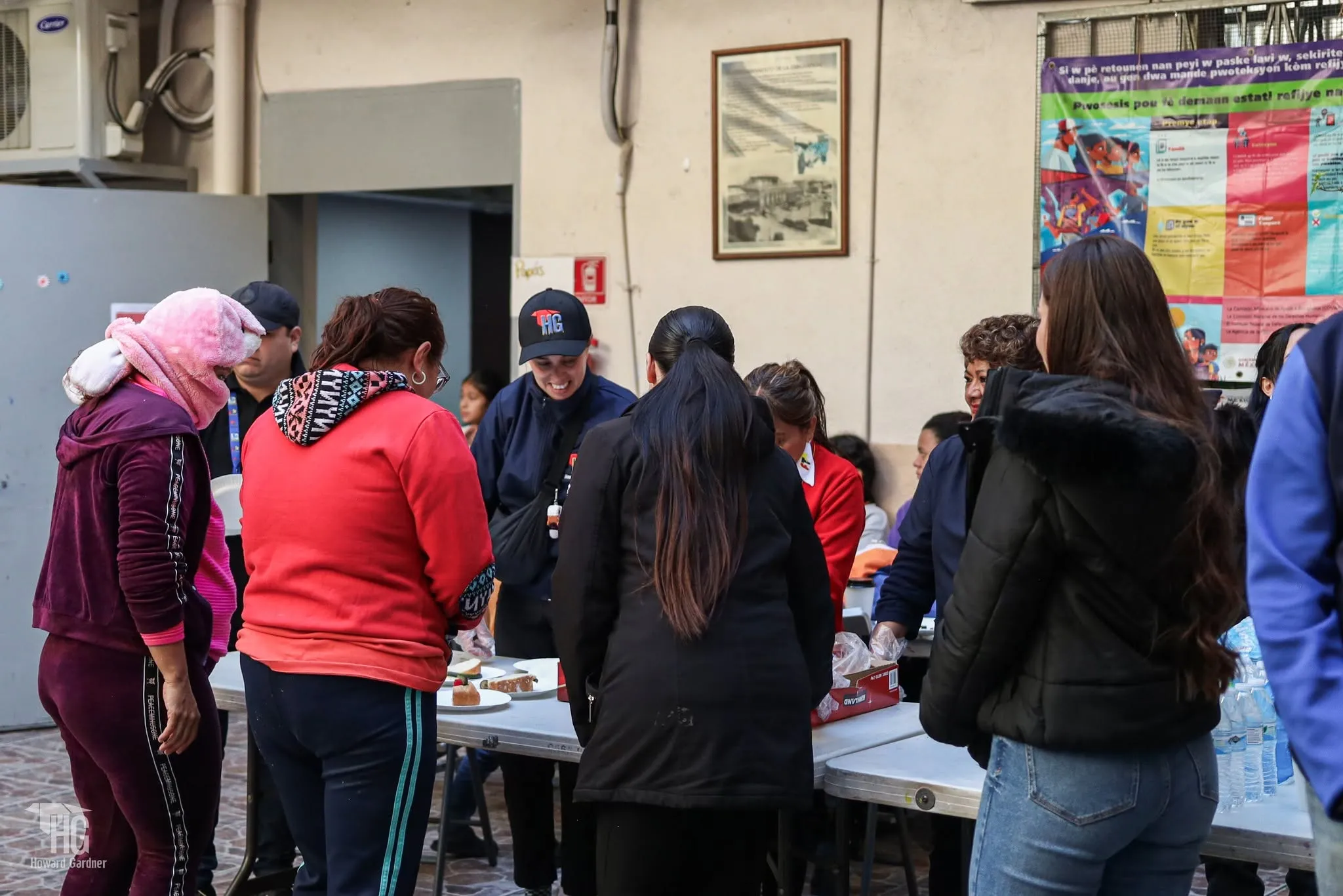 Familias con niñas y niños compartiendo alimento en el patio